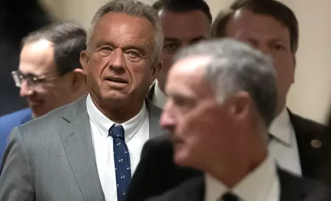 Robert Kennedy Jr., President-elect Donald Trump's pick to lead the Health and Human Services Department, walks between meetings with senators on Capitol Hill, Tuesday, Dec. 17, 2024, in Washington. (AP Photo/Mark Schiefelbein)