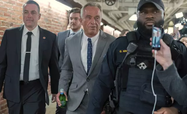 Robert F. Kennedy Jr., President-elect Donald Trump's nominee to be Secretary of Health and Human Services, center, walks to meet with Sen. John Thune, R-S.D. at the Capitol in Washington, Tuesday, Dec. 17, 2024. (AP Photo/Jose Luis Magana)