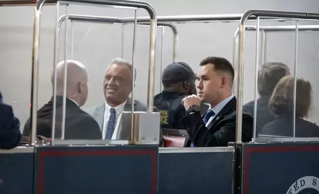 Robert Kennedy Jr., second from right, President-elect Donald Trump's pick to lead the Health and Human Services Department, rides the Capitol subway as he travels between meetings with senators on Capitol Hill, Tuesday, Dec. 17, 2024, in Washington. (AP Photo/Mark Schiefelbein)