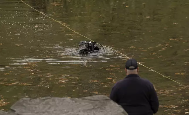 NYPD officers in diving suits search a lake in Central Park, Monday, Dec. 9, 2024, in New York. (AP Photo/Yuki Iwamura)