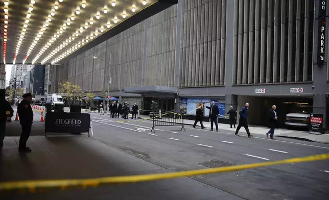 New York police investigators walk along 54th Street outside the Hilton Hotel in midtown Manhattan where Brian Thompson, the CEO of UnitedHealthcare, was fatally shot, Wednesday, Dec. 4, 2024, in New York. (AP Photo/Stefan Jeremiah)