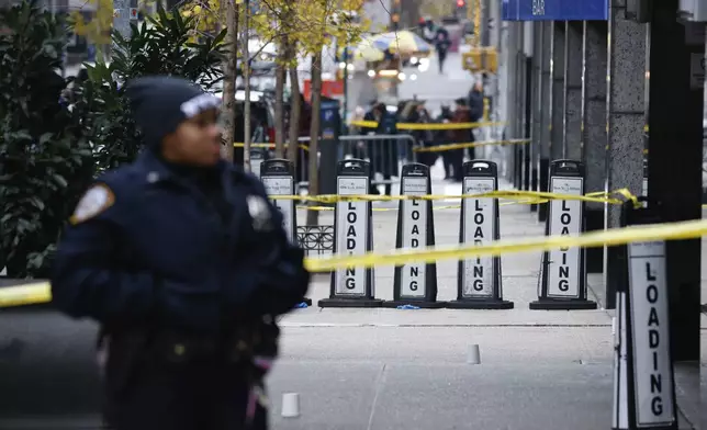 A New York police officer stands outside the Hilton Hotel in midtown Manhattan where Brian Thompson, the CEO of UnitedHealthcare, was fatally shot, Wednesday, Dec. 4, 2024, in New York. (AP Photo/Stefan Jeremiah)