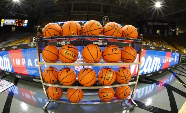 FILE - In this image taken with a fisheye lens , basketballs sit in a rack for players to warm up before an NCAA college basketball game between Colorado and Washington State, Saturday, March 2, 2024, in Boulder, Colo. (AP Photo/David Zalubowski, File)