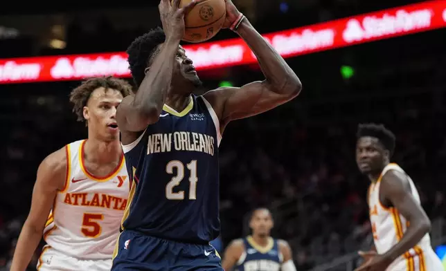 New Orleans Pelicans center Yves Missi (21) heads to the basket against Atlanta Hawks guard Dyson Daniels (5) during the first half of an NBA basketball game, Monday, Dec. 2, 2024, in Atlanta. (AP Photo/Mike Stewart)