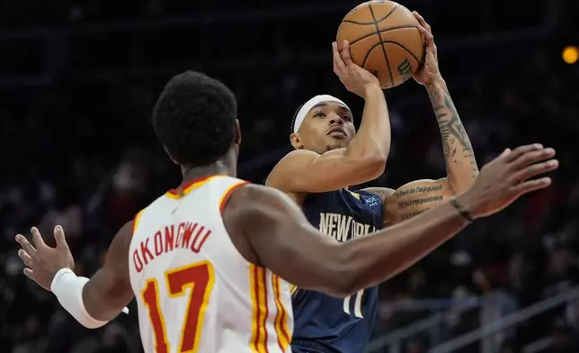 New Orleans Pelicans guard Brandon Boston Jr. (11) shoots against Atlanta Hawks forward Onyeka Okongwu (17) during the first half of an NBA basketball game, Monday, Dec. 2, 2024, in Atlanta. (AP Photo/Mike Stewart)