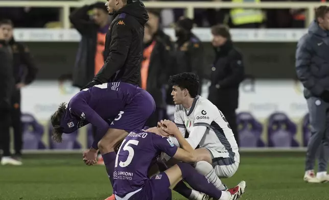 Emotional players comfort each other as Fiorentina's Edoardo Bove, injured, is taken to hospital during the Serie A soccer match between Fiorentina and Inter at the Artemio Franchi Stadium in Florence, Italy, Sunday Dec. 1, 2024. The match was suspended and finally postponed. (Massimo Paolone/LaPresse via AP)