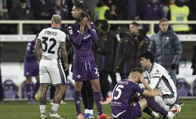 Emotional players comfort each others as Fiorentina's Edoardo Bove, injured, is taken to hospital during the Serie A soccer match between Fiorentina and Inter at the Artemio Franchi Stadium in Florence, Italy, Sunday Dec. 1, 2024. The match was suspended and finally postponed. (Massimo Paolone/LaPresse via AP)