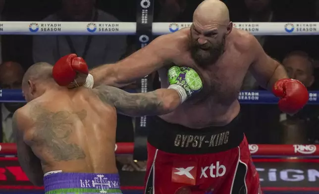 Boxers Britain's Tyson Fury, right, and Ukraine's Oleksandr Usyk compete during their WBA, WBO, and WBC world heavyweight title fight in Riyadh, Saudi Arabia, Saturday, Dec. 21, 2024. (AP Photo/Frank Augstein)