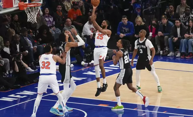 New York Knicks' Mikal Bridges, center, puts up a shot during the first half of an NBA basketball game against the San Antonio Spurs, Wednesday, Dec. 25, 2024, in New York. (AP Photo/Seth Wenig)