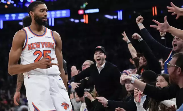 New York Knicks' Mikal Bridges, left, and fans react after Bridges hit a three point basket during the second half of an NBA basketball game, Wednesday, Dec. 25, 2024, in New York. The Knicks defeated the Spurs 117-114. (AP Photo/Seth Wenig)