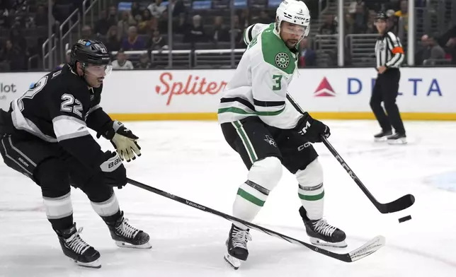 Dallas Stars defenseman Mathew Dumba, right, controls the puck as Los Angeles Kings left wing Kevin Fiala reaches in during the second period of an NHL hockey game, Wednesday, Dec. 4, 2024, in Los Angeles. (AP Photo/Mark J. Terrill)