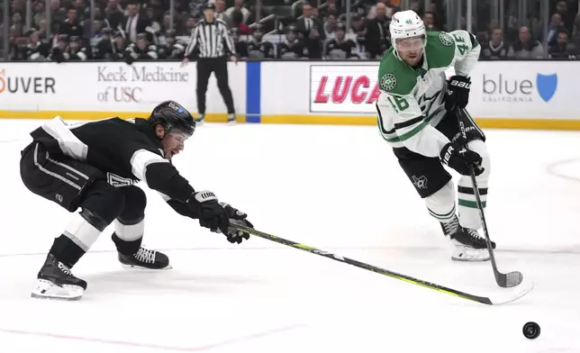 Dallas Stars defenseman Ilya Lyubushkin, right, take the puck as Los Angeles Kings right wing Adrian Kempe reaches in during the second period of an NHL hockey game, Wednesday, Dec. 4, 2024, in Los Angeles. (AP Photo/Mark J. Terrill)