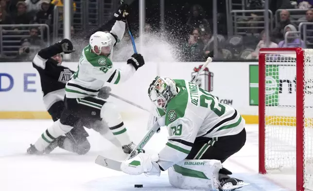 Dallas Stars goaltender Jake Oettinger, right, stops a shot as Los Angeles Kings defenseman Jordan Spence, left, and defenseman Esa Lindell tangle during the second period of an NHL hockey game, Wednesday, Dec. 4, 2024, in Los Angeles. (AP Photo/Mark J. Terrill)