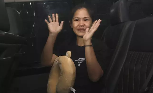 Filipino death row inmate Mary Jane Veloso gestures to the media as she leaves Yogyakarta Women's Prison for her transfer to the capital city of Jakarta in preparation for her repatriation to the Philippines, in Gunung Kidul, Indonesia, Sunday, Dec. 15, 2024. (AP Photo/Slamet Riyadi)