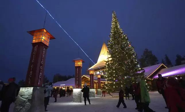 Tourists visit Santa Claus Village, a winter-themed amusement park perched on the edge of the Arctic Circle, in Rovaniemi, Finland, Wednesday, Dec. 4, 2024. (AP Photo/James Brooks)