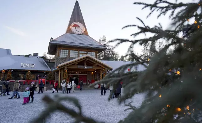 Tourists gathered at Santa Claus Village, a winter-themed amusement park perched on the edge of the Arctic Circle, in Rovaniemi, Finland, Wednesday, Dec. 4, 2024. (AP Photo/James Brooks)