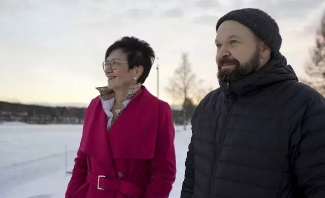 Antti Pakkanen, right, and Taina Torvela, members of a Rovaniemi housing network, stand by the Kemijoki River, in Rovaniemi, Finland, Wednesday, Dec. 4, 2024. (AP Photo/James Brooks)