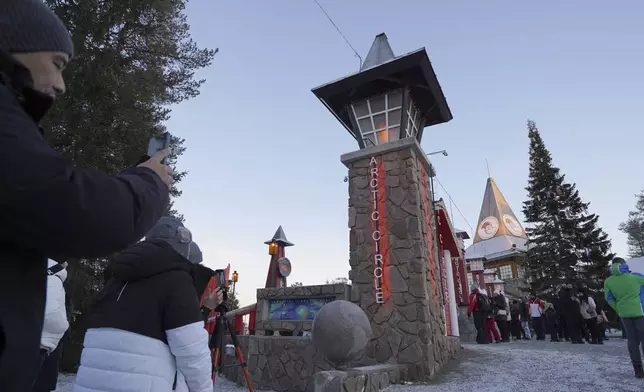 Tourists visit Santa Claus Village, a winter-themed amusement park perched on the edge of the Arctic Circle, in Rovaniemi, Finland, Wednesday, Dec. 4, 2024. (AP Photo/James Brooks)