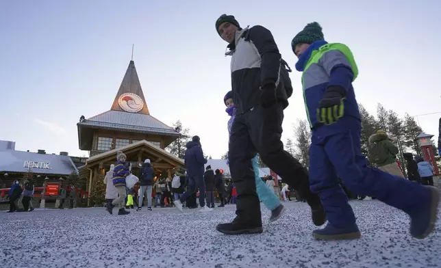 Tourists visit Santa Claus Village, a winter-themed amusement park perched on the edge of the Arctic Circle, in Rovaniemi, Finland, Wednesday, Dec. 4, 2024. (AP Photo/James Brooks)