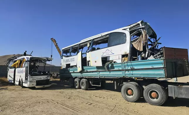 People remove a damaged bus after an accident in Ghazni province, southeastern Afghanistan, Thursday, Dec. 19, 2024. (AP Photo/Gulabuddin Amiri)