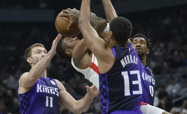 Sacramento Kings forward Domantas Sabonis (11) Keegan Murray, and Malik Monk guard Houston Rockets guard Jalen Green during the first half of an Emirates NBA Cup basketball game in Sacramento, Calif., Tuesday, Dec. 3, 2024. (AP Photo/Randall Benton)