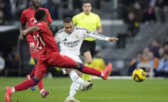 Real Madrid's Kylian Mbappe scores the opening goal during the Spanish La Liga soccer match between Real Madrid and Sevilla at the Santiago Bernabeu Stadium in Madrid, Spain, Sunday, Dec. 22, 2024. (AP Photo/Bernat Armangue)