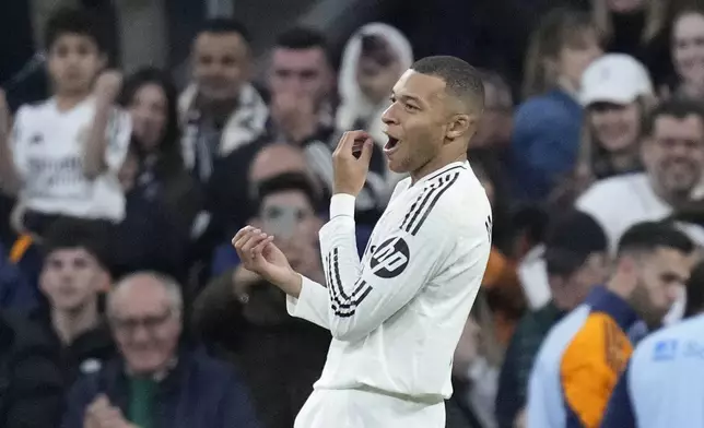 Real Madrid's Kylian Mbappe celebrates after scoring the opening goal during the Spanish La Liga soccer match between Real Madrid and Sevilla at the Santiago Bernabeu Stadium in Madrid, Spain, Sunday, Dec. 22, 2024. (AP Photo/Bernat Armangue)