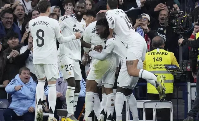 Real Madrid's Kylian Mbappe celebrates with his teammates after scoring the opening goal during the Spanish La Liga soccer match between Real Madrid and Sevilla at the Santiago Bernabeu Stadium in Madrid, Spain, Sunday, Dec. 22, 2024. (AP Photo/Bernat Armangue)