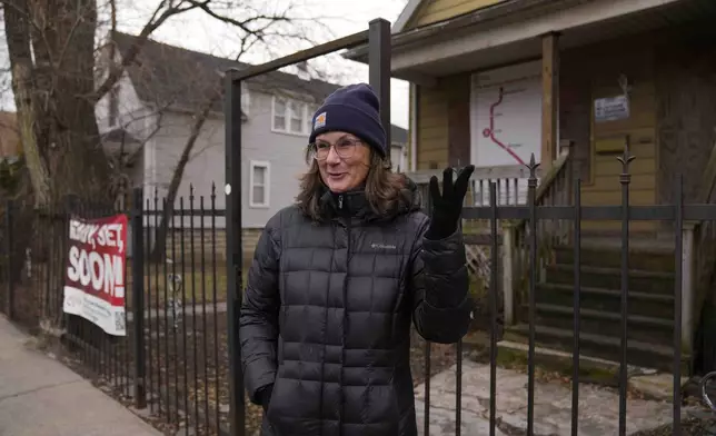 Chicago Transit Authority spokesperson Tammy Chase talks about the expansion of the Red Line train route in front of a boarded-up property set for demolition to make room for a new train station on West 111th Street, Wednesday, Dec. 11, 2024, in the Roseland neighborhood of Chicago. (AP Photo/Erin Hooley)