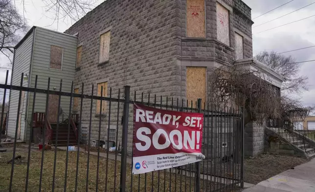 A sign reads "Ready, Set, Soon!" on a boarded-up property set for demolition to make room for a new train station where the Chicago Transit Authority plans to expand the Red Line train route on West 111th Street, Wednesday, Dec. 11, 2024, in the Roseland neighborhood of Chicago. (AP Photo/Erin Hooley)