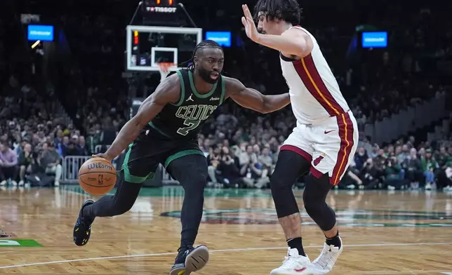 Boston Celtics guard Jaylen Brown (7) drives to the basket against Miami Heat guard Jaime Jaquez Jr., right, during the first half of an NBA basketball game, Monday, Dec. 2, 2024, in Boston. (AP Photo/Charles Krupa)