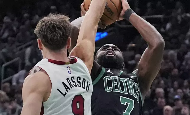 Boston Celtics guard Jaylen Brown (7) tries to shoot over Miami Heat guard Pelle Larsson (9) during the first half of an NBA basketball game, Monday, Dec. 2, 2024, in Boston. (AP Photo/Charles Krupa)