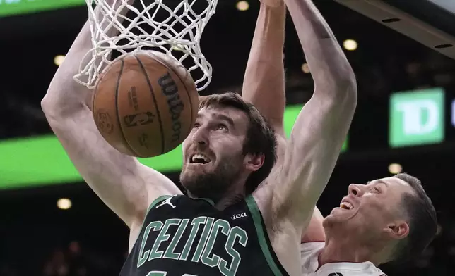 Boston Celtics center Luke Kornet (40) dunks against Miami Heat forward Duncan Robinson, right, during the first half of an NBA basketball game, Monday, Dec. 2, 2024, in Boston. (AP Photo/Charles Krupa)