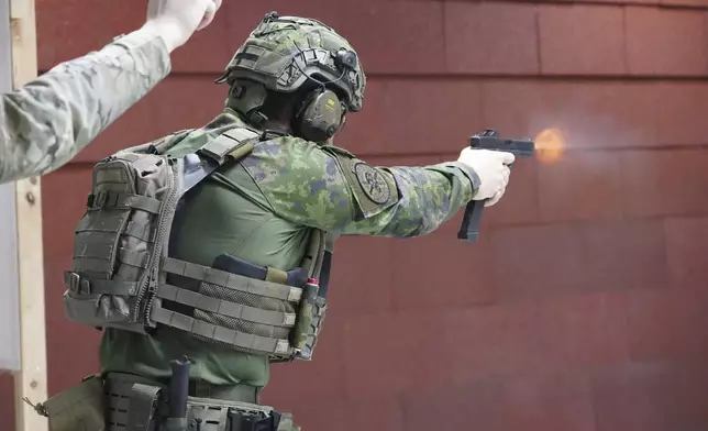 Members of the Vantaa Reservists Association practice at a shooting range in a warehouse in Kerava on the outskirts of Helsinki, Finland Monday, Dec. 2, 2024. (AP Photo/James Brooks)