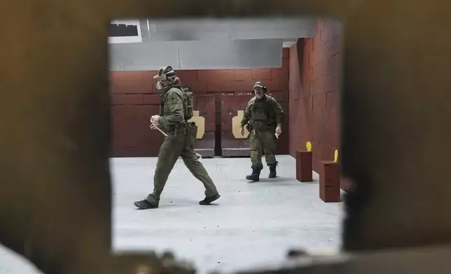 Members of the Vantaa Reservists Association practice at a shooting range in a warehouse in Kerava on the outskirts of Helsinki, Finland Monday, Dec. 2, 2024. (AP Photo/James Brooks)