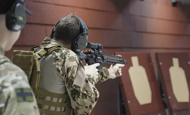 Members of the Vantaa Reservists Association practice at a shooting range in a warehouse in Kerava on the outskirts of Helsinki, Finland, Monday, Dec. 2, 2024. (AP Photo/James Brooks)