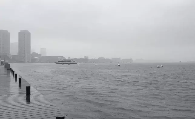 A few boats move through the fog that had descended on the harbor in Boston on Wednesday, Dec. 11, 2024. (AP Photo/Michael Casey)