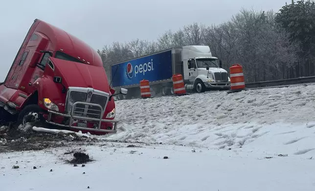 A tractor-trailer hauling a load of oranges sits on the side of the road after sliding off the Maine Turnpike early on Wednesday, Dec. 11, 2024, in New Gloucester, Maine. (AP Photo/David Sharp)