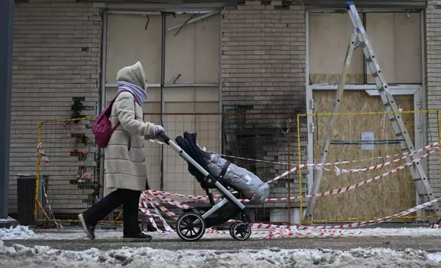 A person walks past an apartment block in Moscow, Russia, Wednesday, Dec. 18, 2024, where a bomb killed Lt. Gen. Igor Kirillov, head of Russia's Radiation, Biological and Chemical Defense Forces and his assistant, Ilya Polikarpov. (AP Photo/Dmitry Serebryakov)