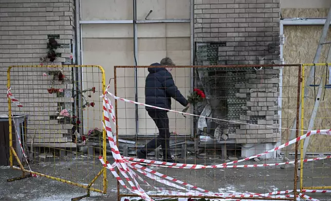 A man lays flowers on Wednesday, Dec. 18, 2024, at the apartment block in Moscow, Russia, where a bomb killed Lt. Gen. Igor Kirillov, the head of Russia's Radiation, Biological and Chemical Defense Forces, and his assistant Ilya Polikarpov. (AP Photo/Dmitry Serebryakov)