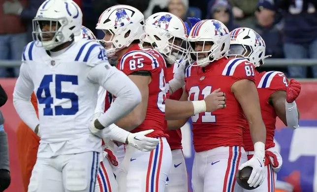 New England Patriots tight end Austin Hooper (81) celebrates after his touchdown with teammates behind Indianapolis Colts linebacker E.J. Speed (45) during the first half of an NFL football game, Sunday, Dec. 1, 2024, in Foxborough, Mass. (AP Photo/Steven Senne)