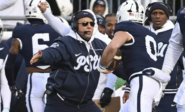 Penn State linebacker Dominic DeLuca celebrates an interception for a touchdown with head coach James Franklin against SMU during the first half in the first round of the NCAA College Football Playoff, Saturday, Dec. 21, 2024, in State College, Pa. (AP Photo/Barry Reeger)