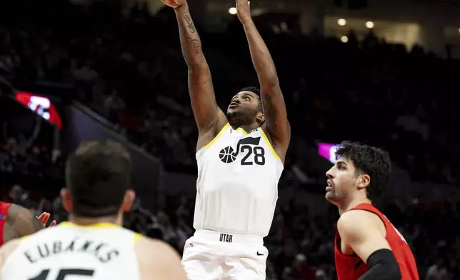 Utah Jazz forward Brice Sensabaugh, middle, shoots the ball against the Portland Trail Blazers during the second half of an NBA basketball game Thursday, Dec. 26, 2024, in Portland, Ore. (AP Photo/Howard Lao)