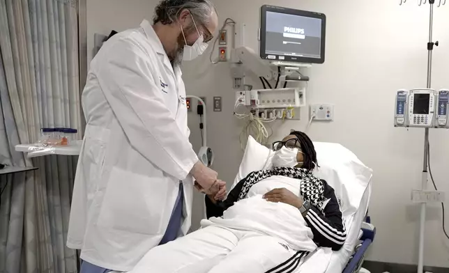 Pig kidney recipient Towana Looney is visited by Dr. Robert Montgomery of NYU Langone Health, center, on Dec. 10, 2024, at NYU Langone Health, in New York City. (AP Photo/Shelby Lum)