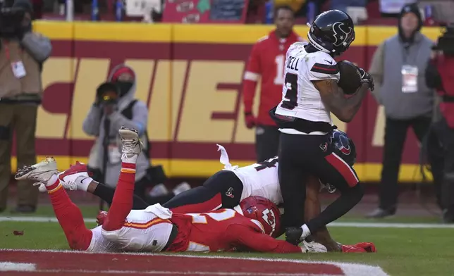 Houston Texans wide receiver Tank Dell (3) catches a touchdown pass as Kansas City Chiefs cornerback Trent McDuffie, left, defends during the second half of an NFL football game Saturday, Dec. 21, 2024, in Kansas City, Mo. Dell was injured on the play. (AP Photo/Charlie Riedel)