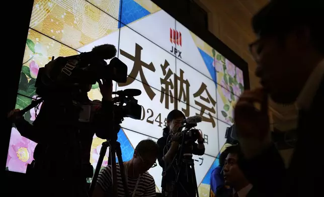 Media wait for the ceremony to mark the last trading day of the year at the Tokyo Stock Exchange Monday, Dec. 30, 2024, in Tokyo. (AP Photo/Eugene Hoshiko)