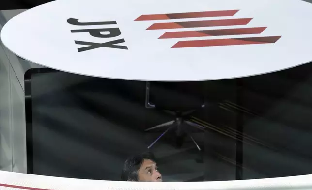 A staff works on the last trading day of the year at the Tokyo Stock Exchange Monday, Dec. 30, 2024, in Tokyo. (AP Photo/Eugene Hoshiko)