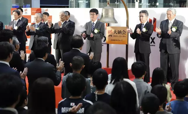 Participants perform a traditional hand clap at the end of a ceremony to conclude the year's trading at the Tokyo Stock Exchange Monday, Dec. 30, 2024, in Tokyo. (AP Photo/Eugene Hoshiko)