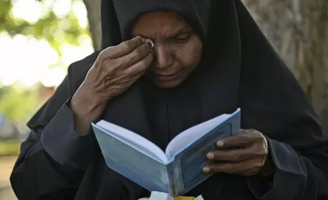 A woman weeps as she prays at a mass grave at victims of the 2004 Indian Ocean tsunami, in Banda Aceh, Indonesia, Thursday, Dec. 26, 2024. (AP Photo/Reza Saifullah)