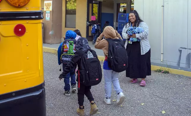 Social worker Mary Schmauss, right, greets students as they arrive for school, Tuesday, Oct. 1, 2024, at Algodones Elementary School in Algodones, N.M. (AP Photo/Roberto E. Rosales)